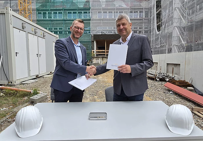 Oberbürgermeister Holm Große (rechts) und SAKD-Direktor Thomas Berndt, der die Anstalt seit Oktober 2024 leitet, bei der Mietvertragsunterzeichnung inmitten der KKB-Baustelle.