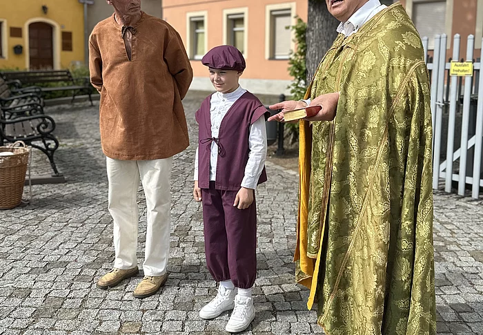 Gottfried Brückner (rechts) führt als Bischof durch die Stadt. Hier begegnet er den Töpfern auf dem Neumarkt, dem früheren „Toppmarkt“. Auch junge Bischofswerdaer beteiligen sich an den „Lebendigen Stadtführungen“, hier Adam Büchler (Mitte) als Töpferjunge. Foto: Stadt Bischofswerda